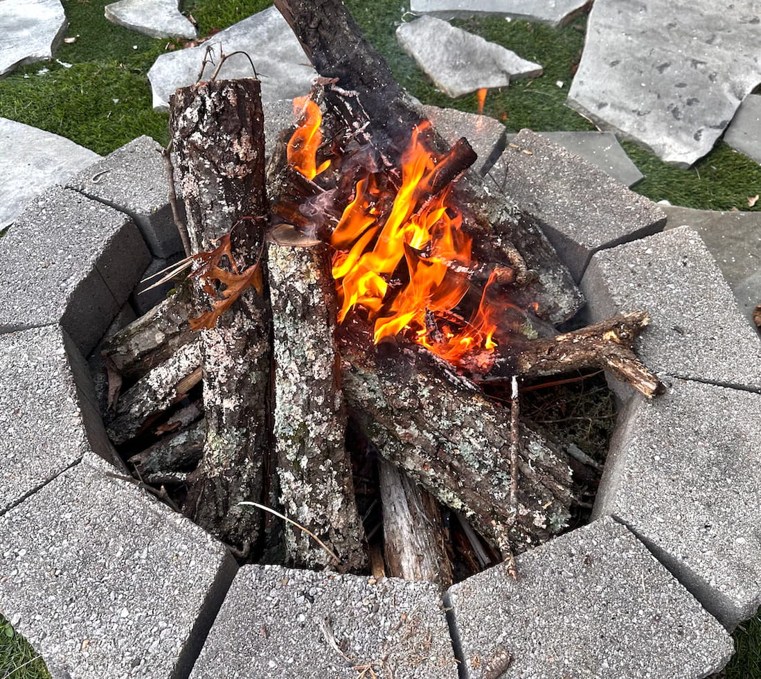 Relaxing campfire with glowing flames and stacked logs, illustrating the emotional benefits of a campfire